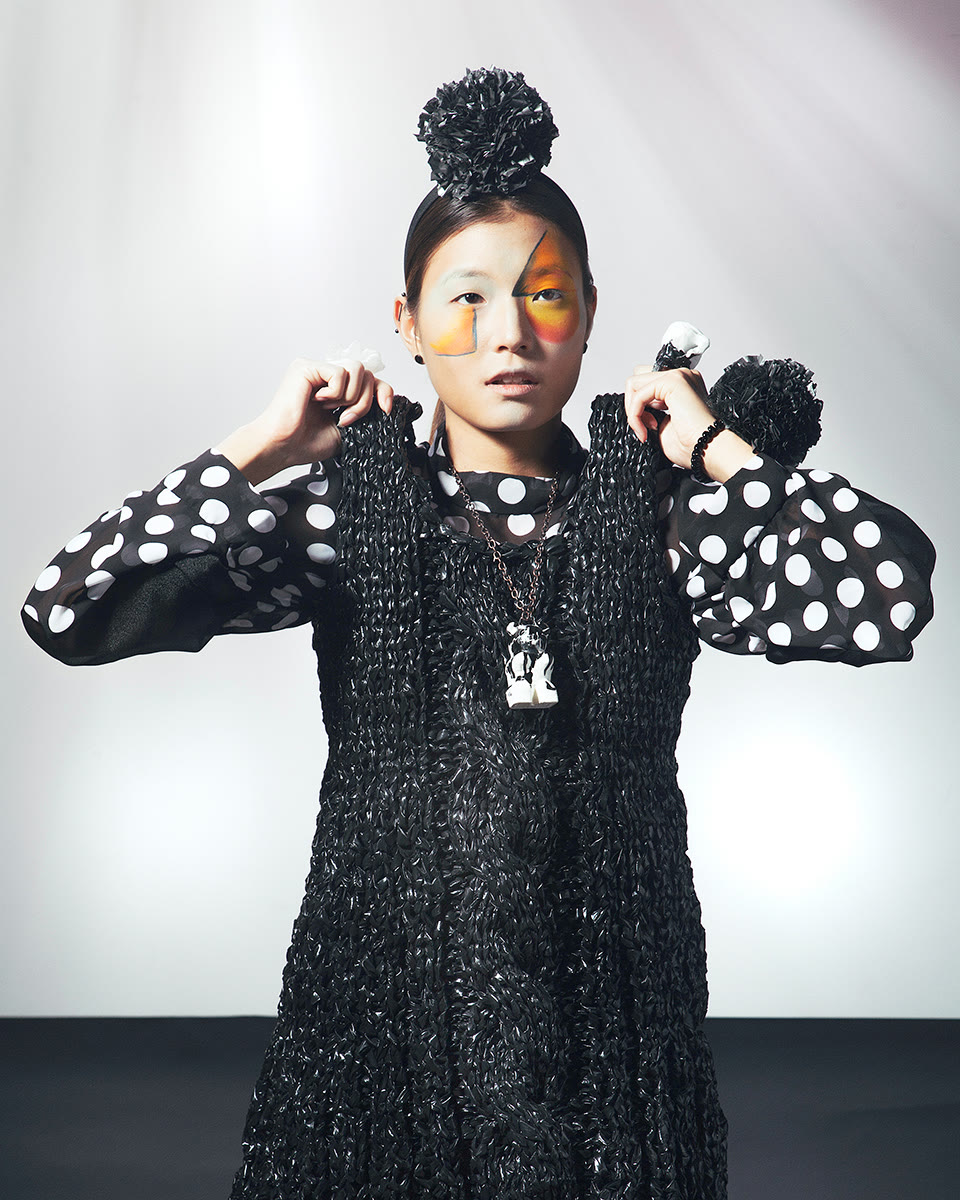 Black textured knit dress layered over a polka-dot underlook