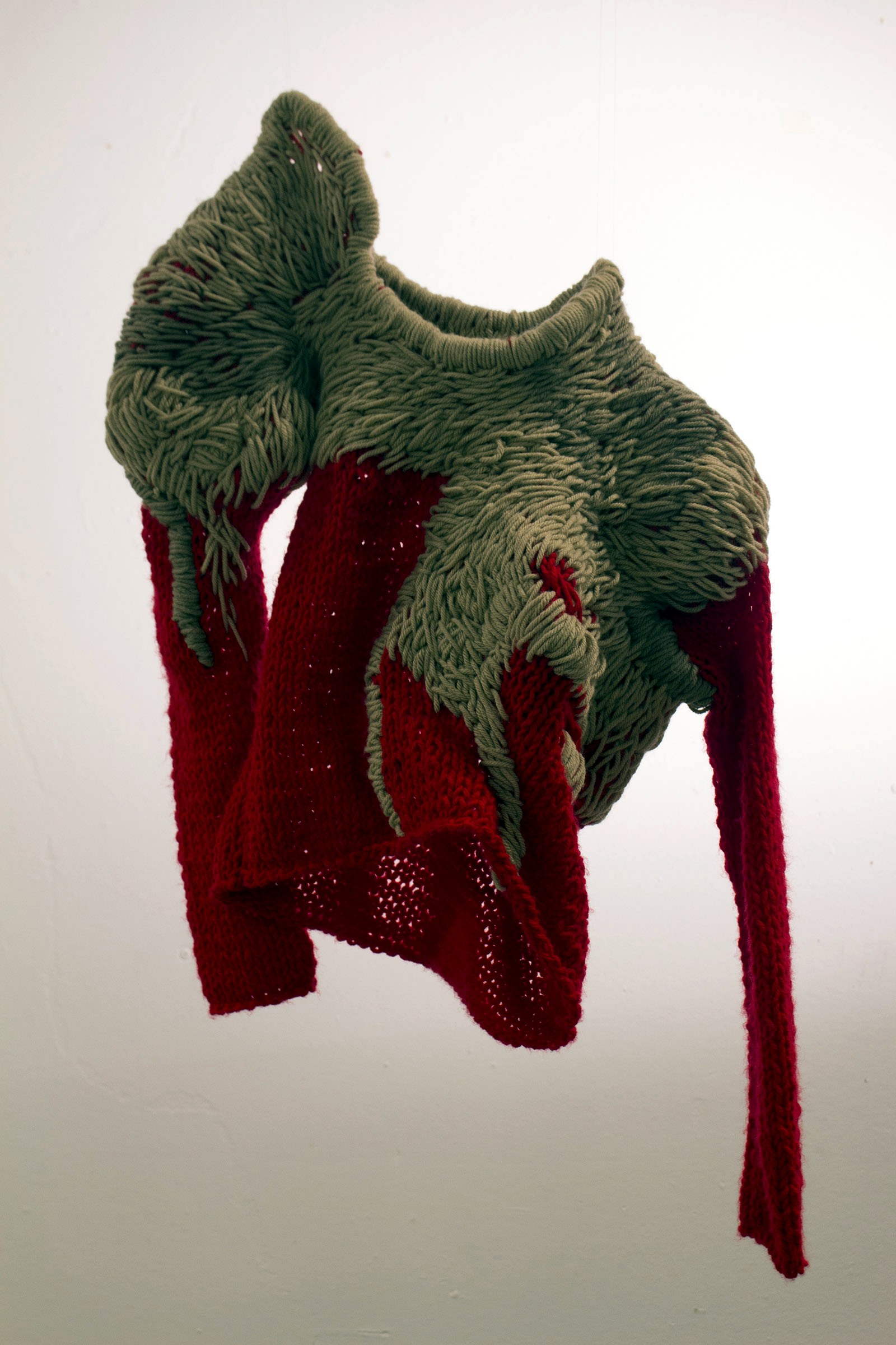 Sculptural knit garment with overscale taupe loop structure over red knit ground